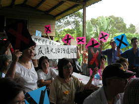 7月9日縣府召開道路工程說明會,竹圍民眾高舉白布條及X牌表達反對立場(攝影/戴瑞君)